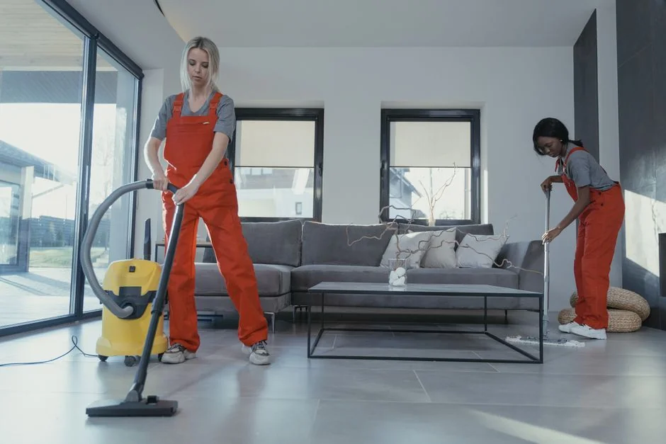 A woman carefully encloses a sofa in protective wrapping while arranging boxes in a well-lit room.